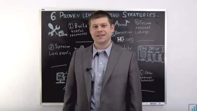Man in gray suit teaches 6 proven leadership strategies on blackboard in educational setting.