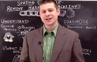 Young man leading SEO workshop, explaining Google penalties and backlink strategies on chalkboard.