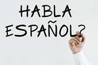 Hand writes HABLA ESPAÑOL? on whiteboard, questioning Spanish language proficiency.