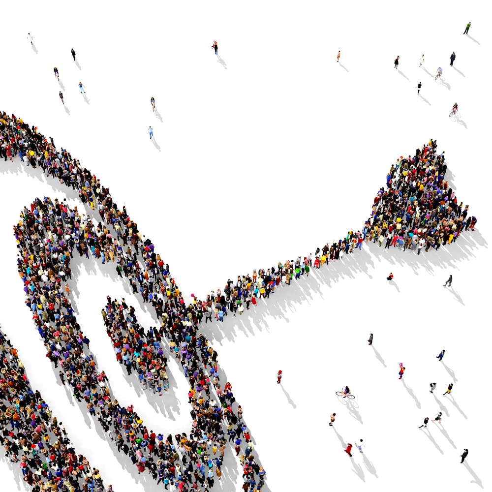 Crowd forms stethoscope shape, symbolizing healthcare unity, in aerial view.