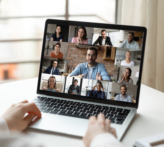 Laptop screen with nine participants in a diverse virtual meeting setup.