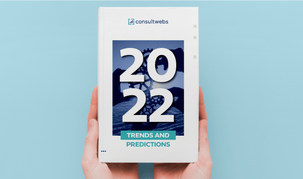 Hands holding 2022 industry forecast and insights report against a light blue background.