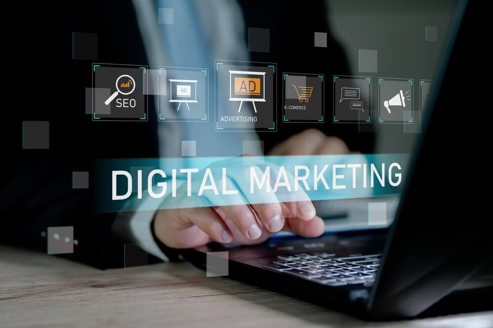Businessman using laptop with digital marketing icon on virtual screen.